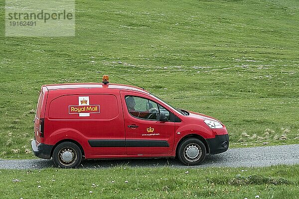 Postbote fährt mit rotem Peugeot Partner Royal Mail Postauto über trostlose Straße in Shetland  Schottland  UK
