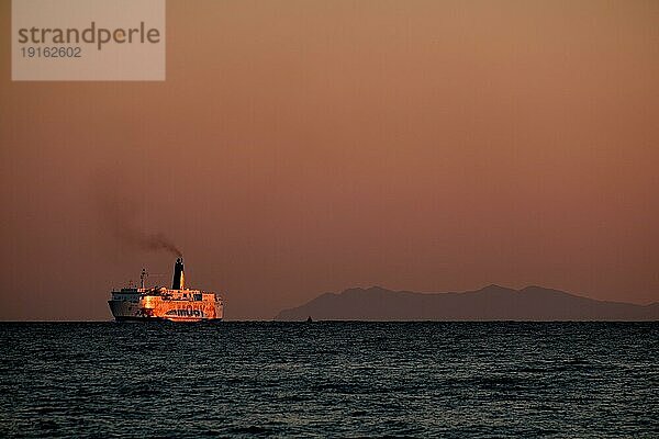 Fähre bei Sonnenaufgang auf dem Mittelmeer. Im Hintergrund sind die Umrisse der Insel Elba  Italien  erkennbar  Europa