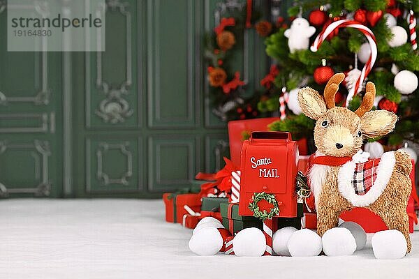 Weihnachtsbanner mit Rentieren  rotem Weihnachtsmann Postkasten und Geschenkboxen vor einem Baum mit grünem Hintergrund mit Kopierraum