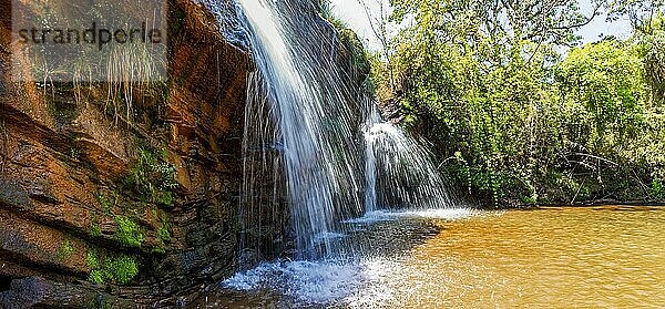 Schöner Wasserfall inmitten von Felsen und Wald im Naturschutzgebiet Muaimii im Bundesstaat Minas Gerais an einem sonnigen Tag