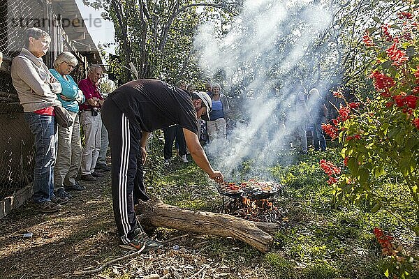 Kirgisischer Mann  der auf einem traditionellen Steingrill in Kirgisistan Essen für Touristen zubereitet