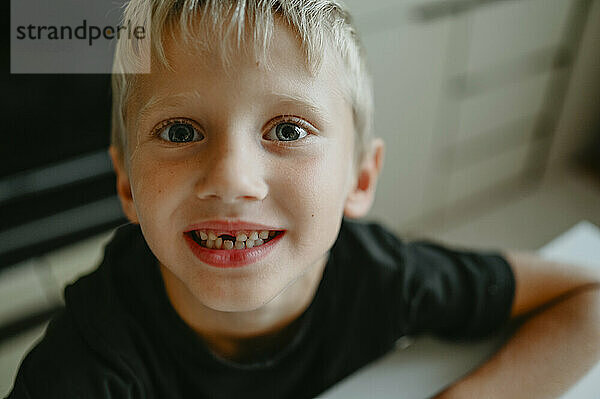 Smiling boy with gap tooth at home