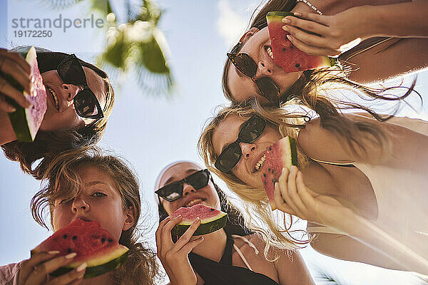 Freunde essen an einem sonnigen Tag Wassermelone