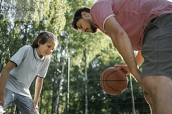 Vater bringt Sohn bei  Basketball zu dribbeln