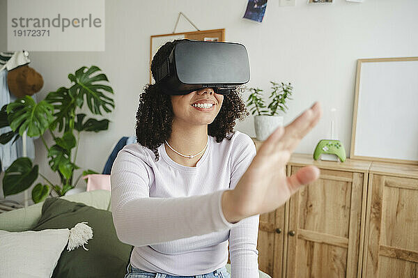 Fröhliches Mädchen gestikuliert mit Virtual-Reality-Simulatoren