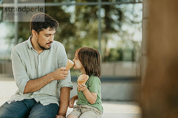 Vater füttert Sohn mit Eis