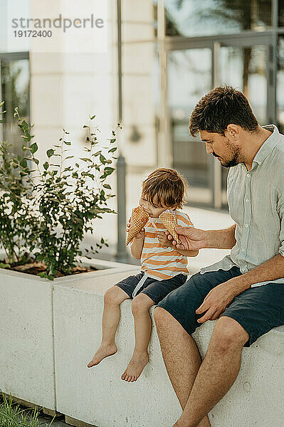 Vater und Sohn essen gemeinsam Eis