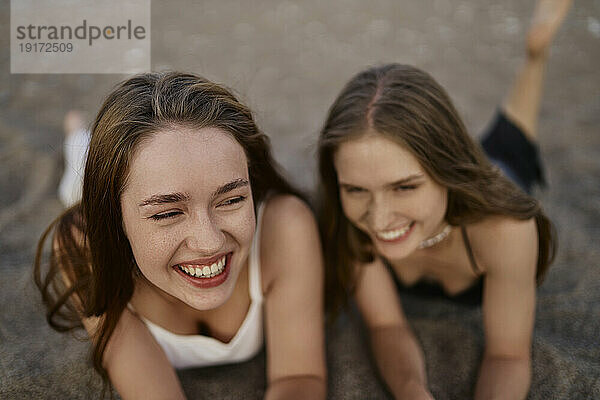Young friends laughing and enjoying at beach on vacation