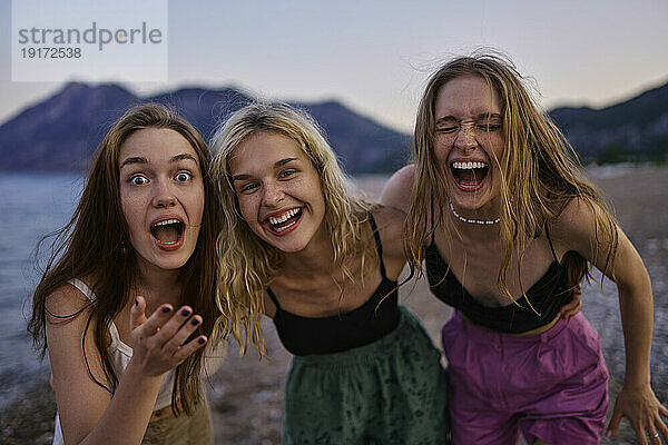 Fröhliche Freunde lachen im Urlaub am Strand