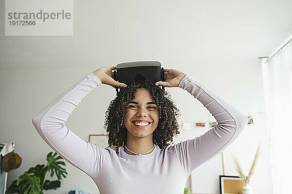 Happy teenage girl with virtual reality simulators at home