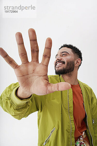 Smiling man gesturing against white background