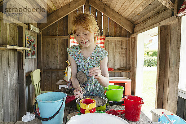 Girl playing with toys in playground house