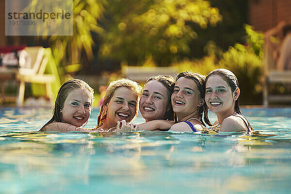 Fröhliche Freunde  die im Urlaub gemeinsam im Schwimmbad Spaß haben