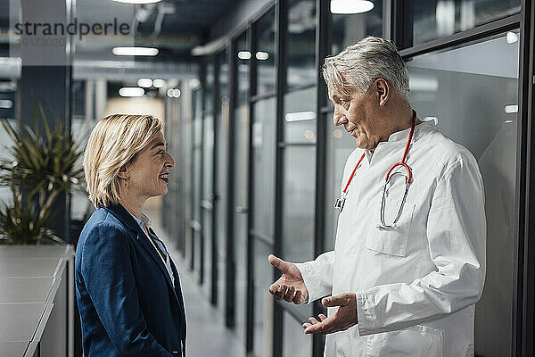 Lächelnder Patient  der dem Arzt im Krankenhaus zuhört