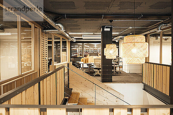 Illuminated office with wooden staircase