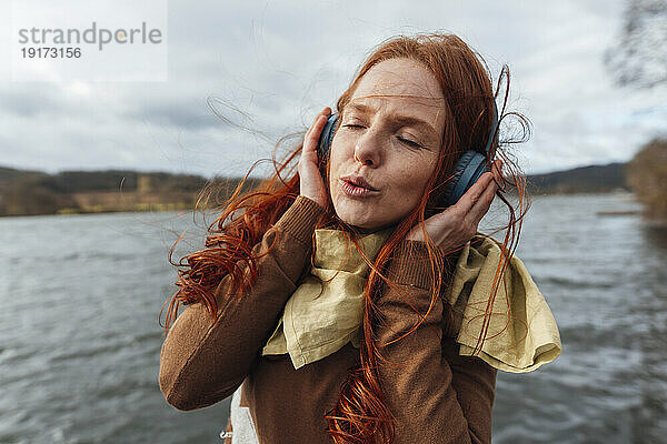 Frau mit geschlossenen Augen hört Musik über kabellose Kopfhörer