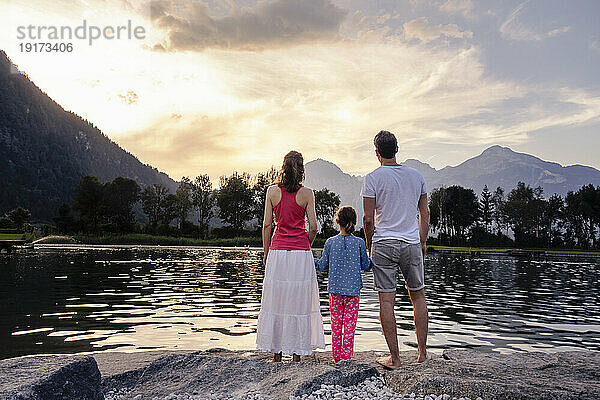 Family admiring lake and mountains at sunset
