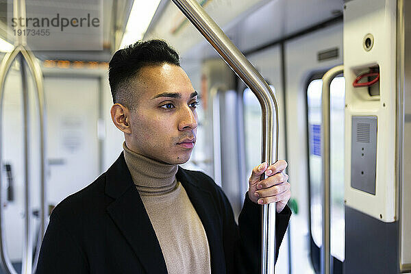Contemplative man standing in train