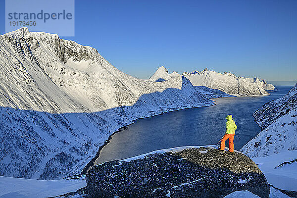 Norway  Troms og Finnmark  Female hiker admiring Oyfjord from Daven mountain
