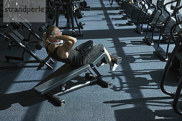 Starker Mann macht Bauchübungen im Fitnessstudio