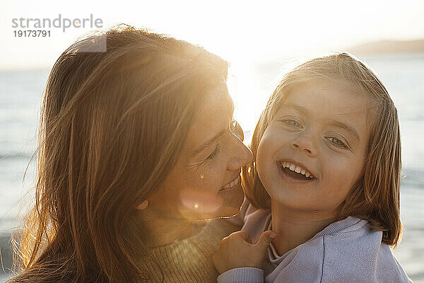 Cheerful mother and daughter enjoying at beach