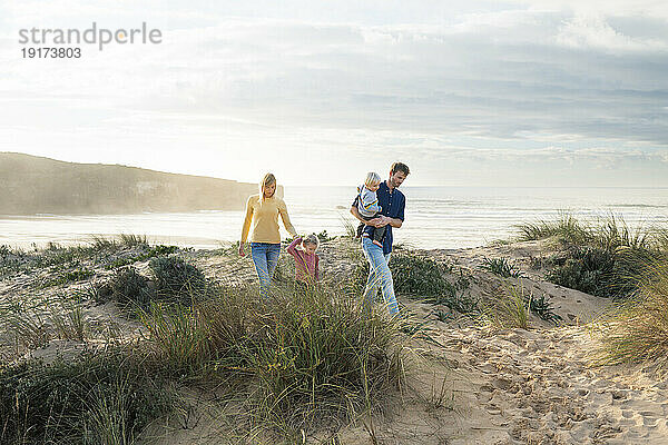 Glückliche Familie  die zusammen am Strand spaziert