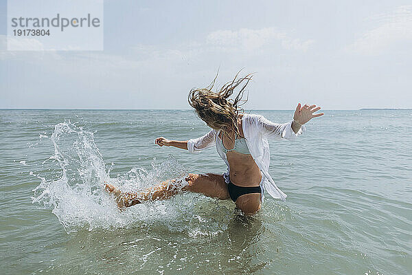 Frau spielt im Meerwasser