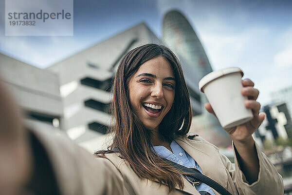 Glückliche junge Frau  die ein Selfie mit einer Kaffeetasse macht