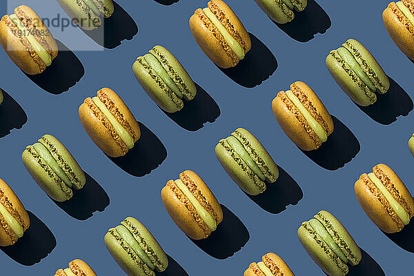 Yellow and green macaroons on blue background