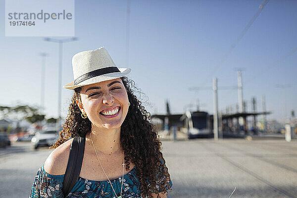 Glückliche Frau mit Hut an einem sonnigen Tag
