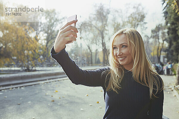 Lächelnde Frau  die ein Selfie mit dem Smartphone macht