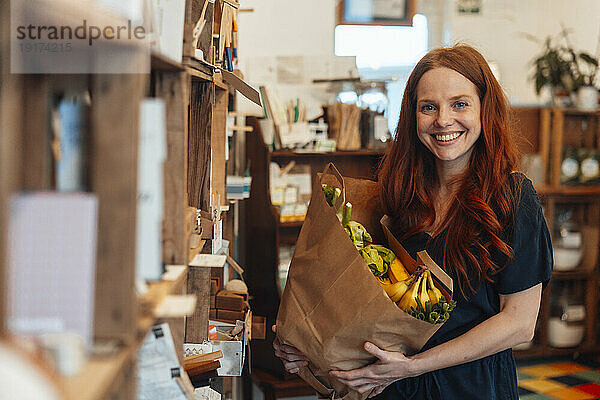 Happy woman doing grocery shopping at store