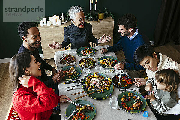 Fröhliche  gemischtrassige Familie  die an Weihnachten eine Dinnerparty genießt