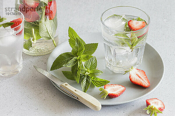 Studioaufnahme von Gläsern angereichertem Wasser mit Minze und Erdbeeren