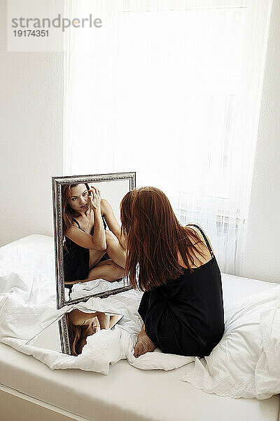 Frau schaut sich zu Hause im Spiegel an
