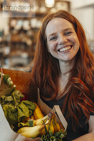 Happy redhead woman shopping for groceries