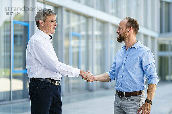 Business partners shaking hands after successful meeting