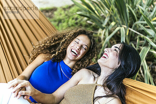 Happy lesbian couple laughing in hammock