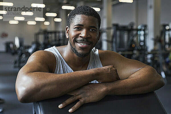 Lächelnder junger Mann im Fitnessstudio