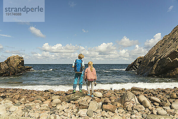 Bruder und Schwester stehen an der Küste am Strand