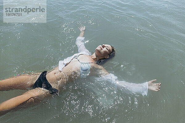 Frau schwimmt auf dem Wasser im Meer