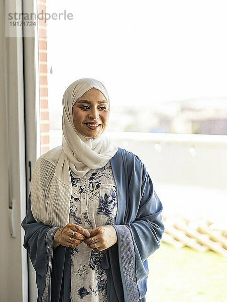 Lächelnder junger Hochzeitsdesigner im Hijab