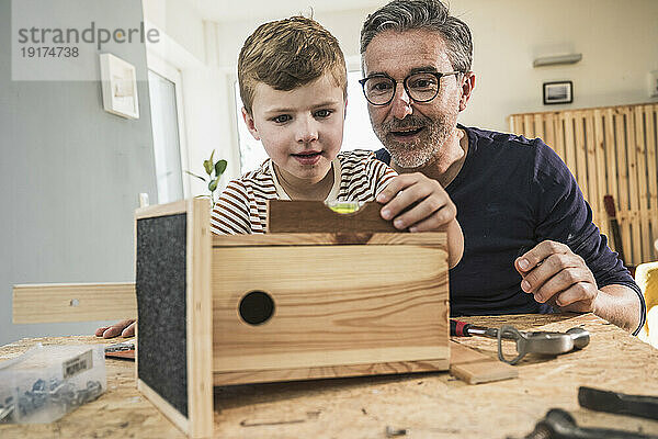 Junge baut Vogelhaus mit Großvater im Wohnzimmer