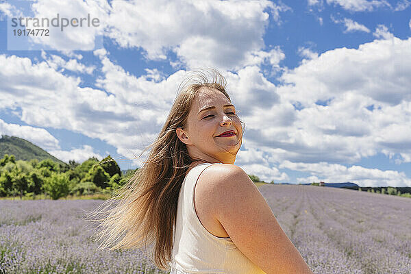 Sorglose Frau genießt das Lavendelfeld unter bewölktem Himmel