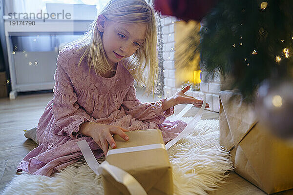 Mädchen schaut sich im Weihnachtsurlaub ein Geschenk an