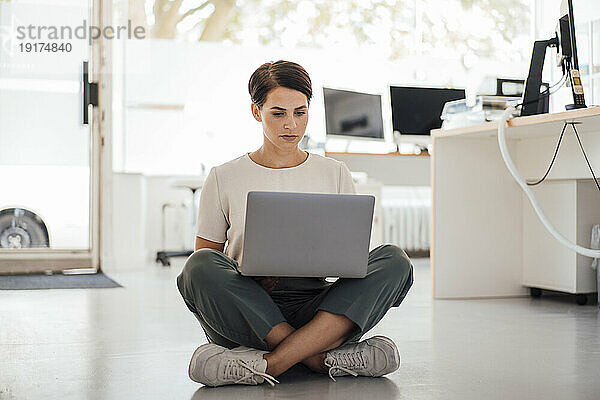 Geschäftsfrau arbeitet am Laptop und sitzt am Arbeitsplatz