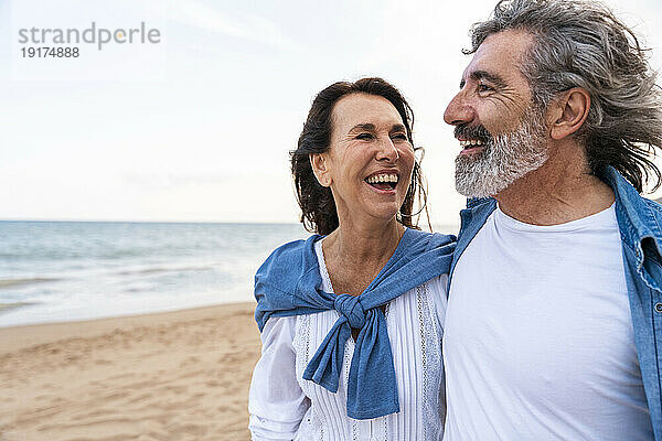 Fröhliches älteres Paar verbringt seine Freizeit am Strand