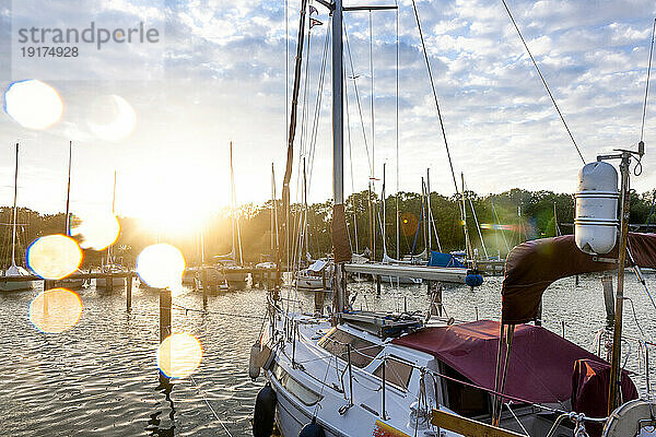 Deutschland  Mecklenburg-Vorpommern  Krummin  Boot liegt im Yachthafen mit untergehender Sonne im Hintergrund