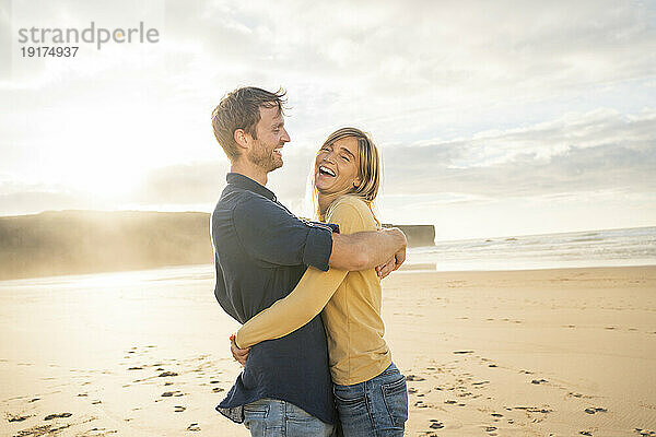Glückliches Paar umarmt sich und genießt den Urlaub am Strand