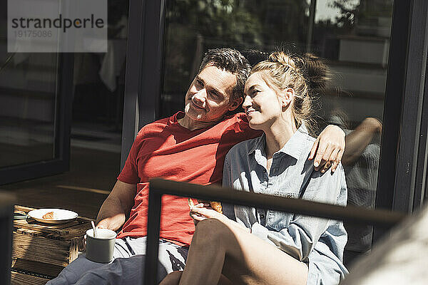 Erwachsenes Paar entspannt sich gemeinsam auf dem Balkon